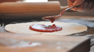 pizza applying sauce